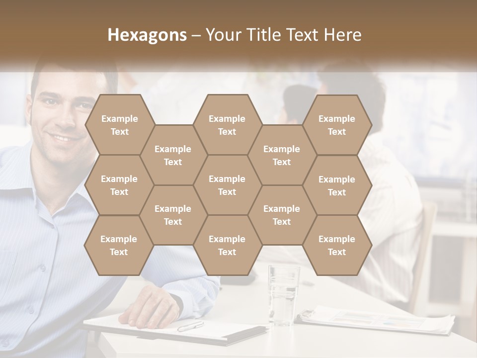 A Man Sitting At A Desk In Front Of A Group Of People PowerPoint Template