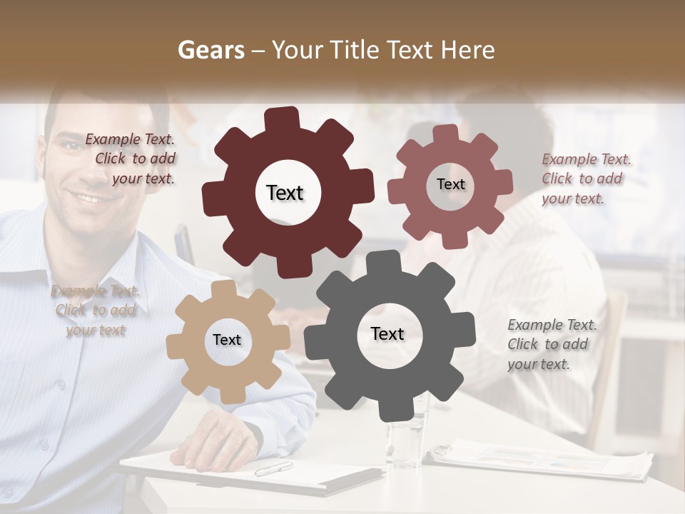 A Man Sitting At A Desk In Front Of A Group Of People PowerPoint Template