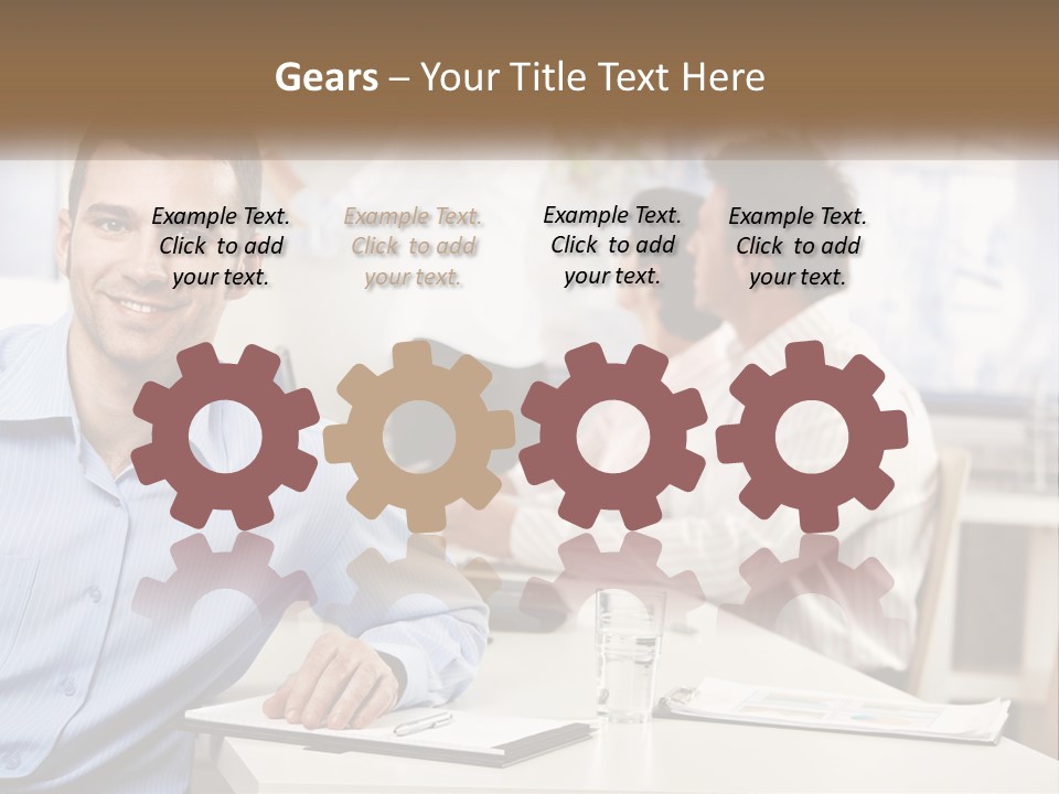 A Man Sitting At A Desk In Front Of A Group Of People PowerPoint Template