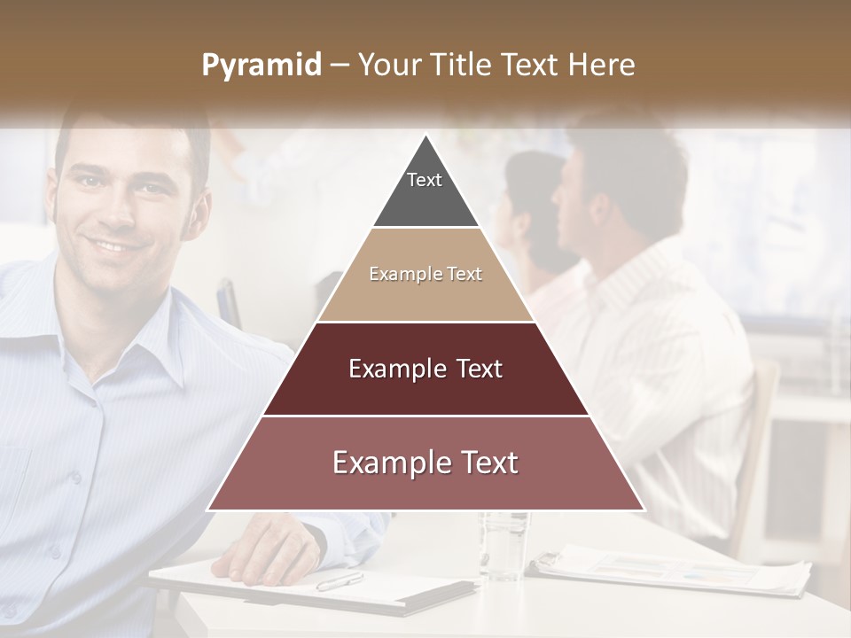 A Man Sitting At A Desk In Front Of A Group Of People PowerPoint Template