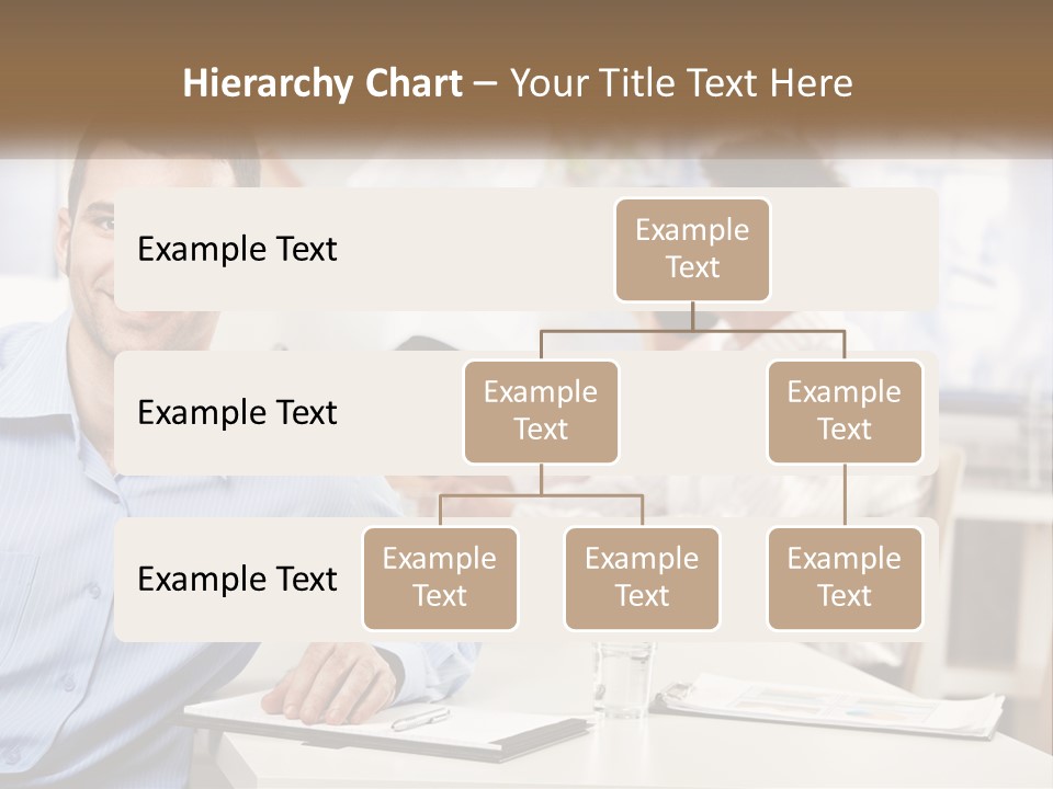 A Man Sitting At A Desk In Front Of A Group Of People PowerPoint Template