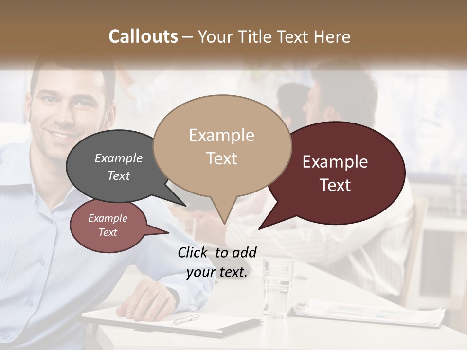 A Man Sitting At A Desk In Front Of A Group Of People PowerPoint Template