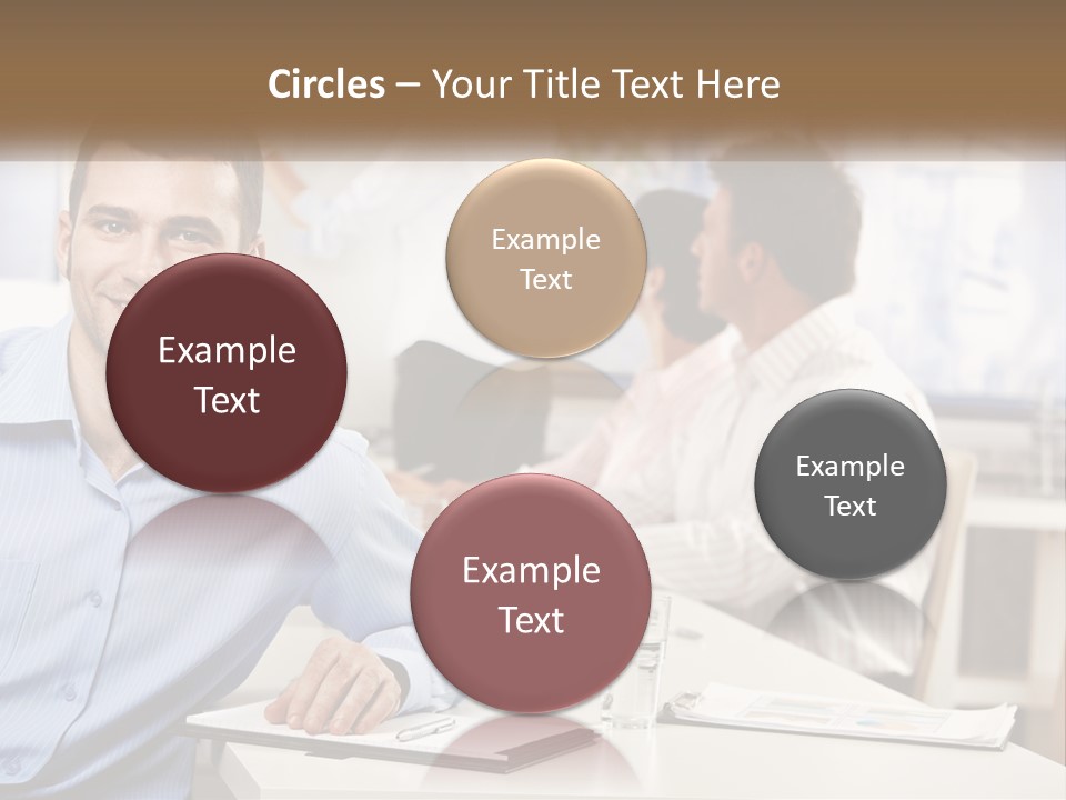 A Man Sitting At A Desk In Front Of A Group Of People PowerPoint Template