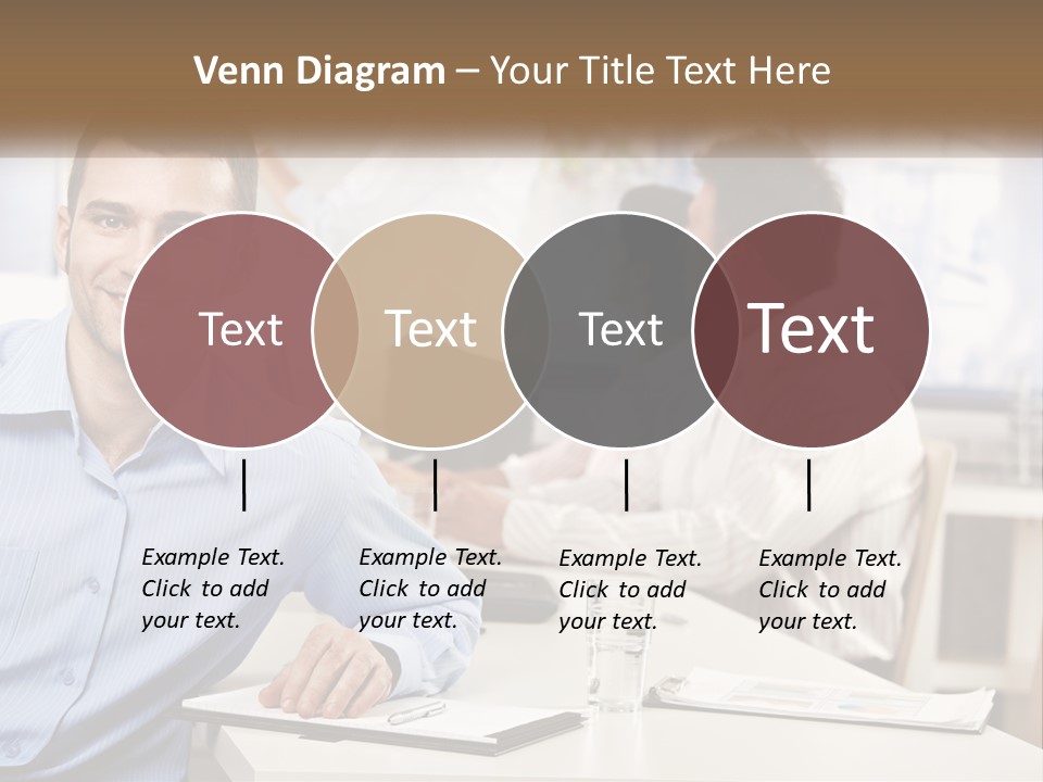 A Man Sitting At A Desk In Front Of A Group Of People PowerPoint Template