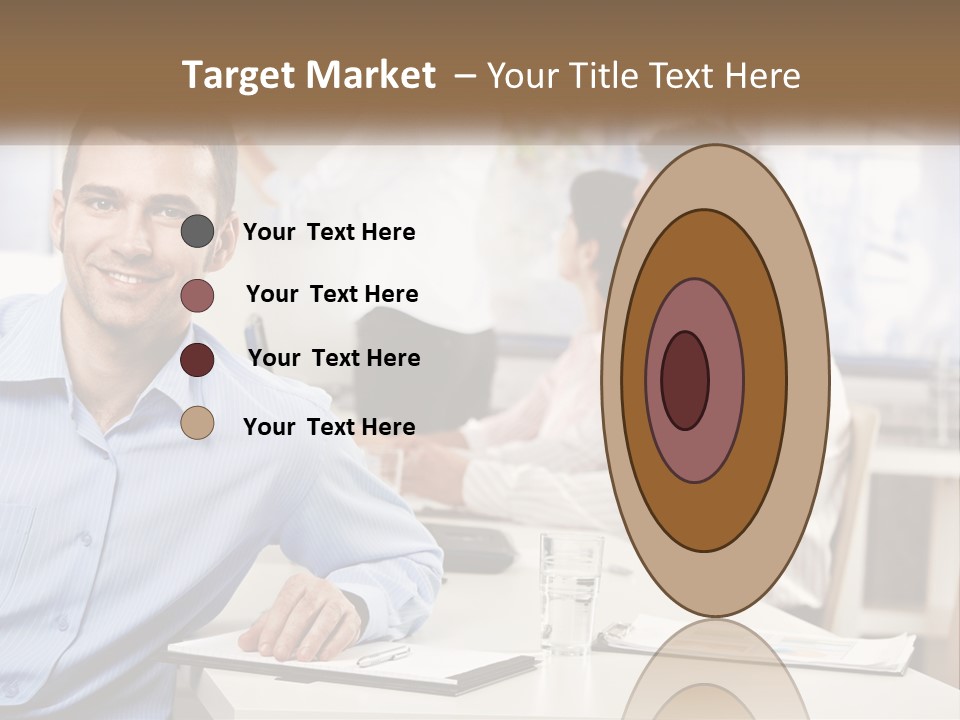 A Man Sitting At A Desk In Front Of A Group Of People PowerPoint Template