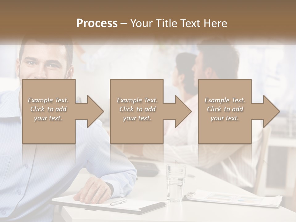 A Man Sitting At A Desk In Front Of A Group Of People PowerPoint Template