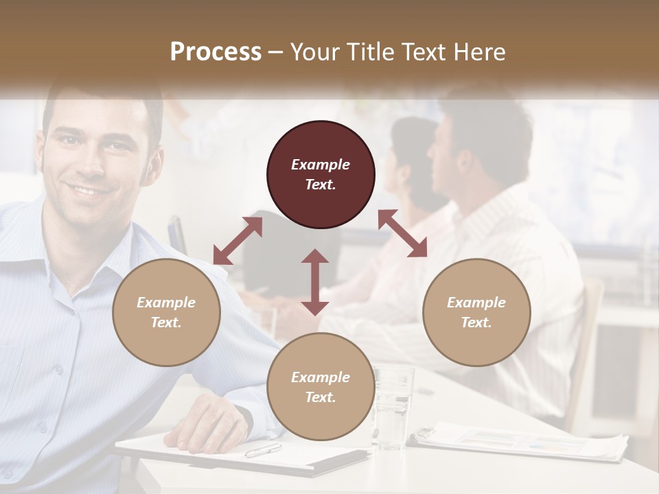 A Man Sitting At A Desk In Front Of A Group Of People PowerPoint Template