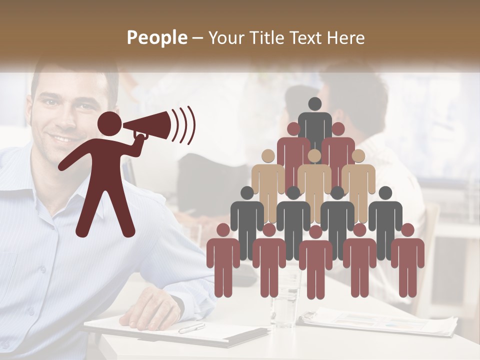 A Man Sitting At A Desk In Front Of A Group Of People PowerPoint Template