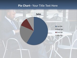 A Man In A Suit Sitting At A Table With A Laptop PowerPoint Template