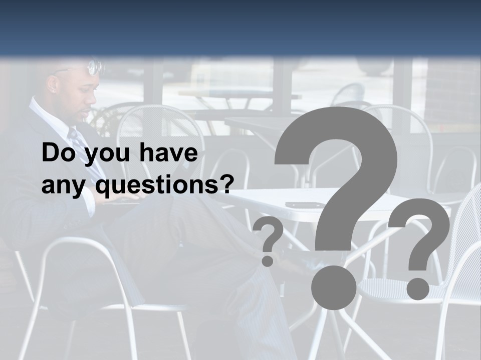 A Man In A Suit Sitting At A Table With A Laptop PowerPoint Template