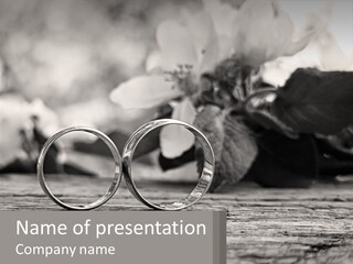 Two Wedding Rings Sitting On Top Of A Wooden Table PowerPoint Template