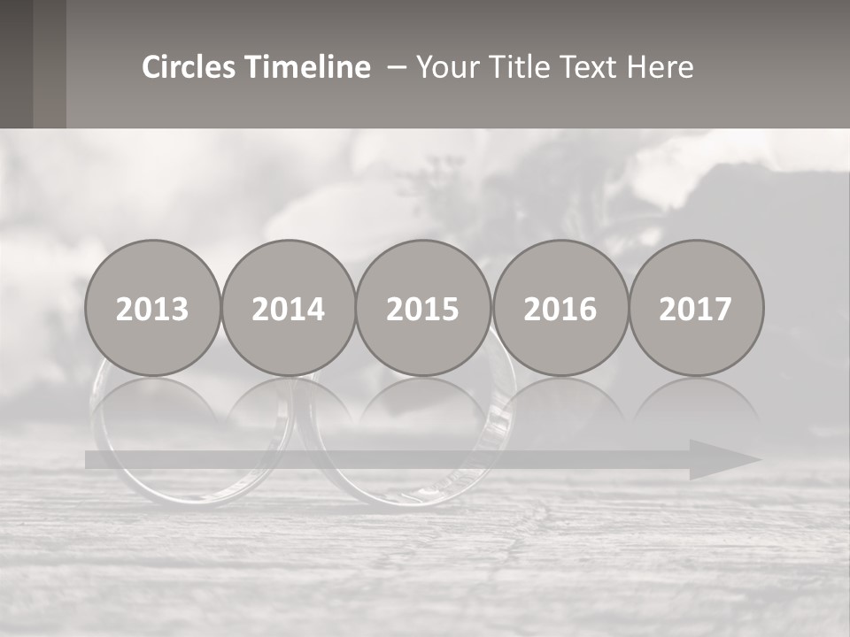 Two Wedding Rings Sitting On Top Of A Wooden Table PowerPoint Template