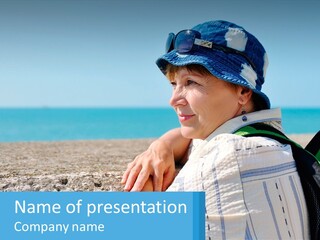 A Woman Sitting On The Beach Wearing A Blue Hat PowerPoint Template