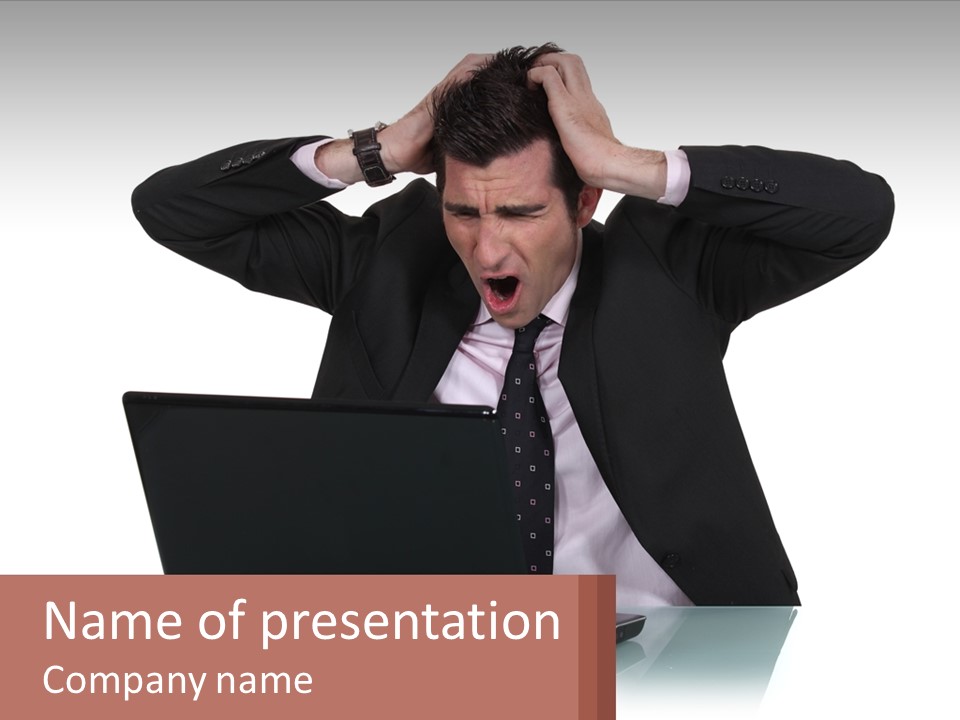 A Man In A Suit Holding His Head While Looking At A Laptop PowerPoint Template