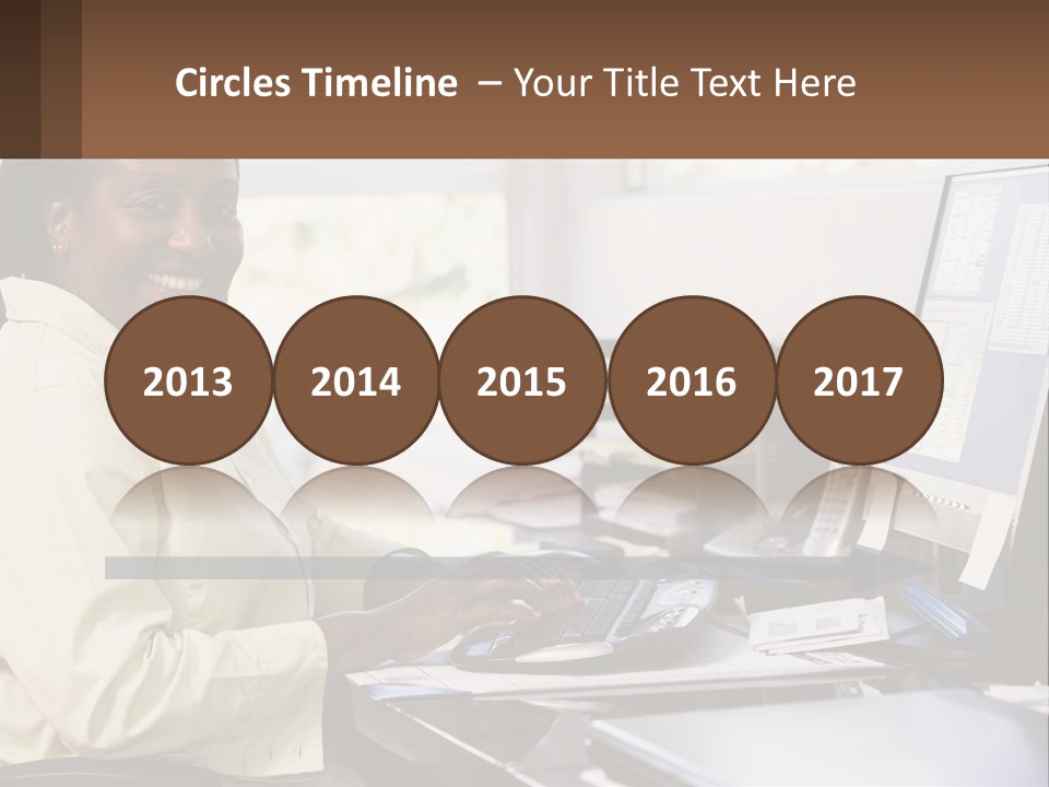 A Woman Sitting At A Desk With A Computer PowerPoint Template