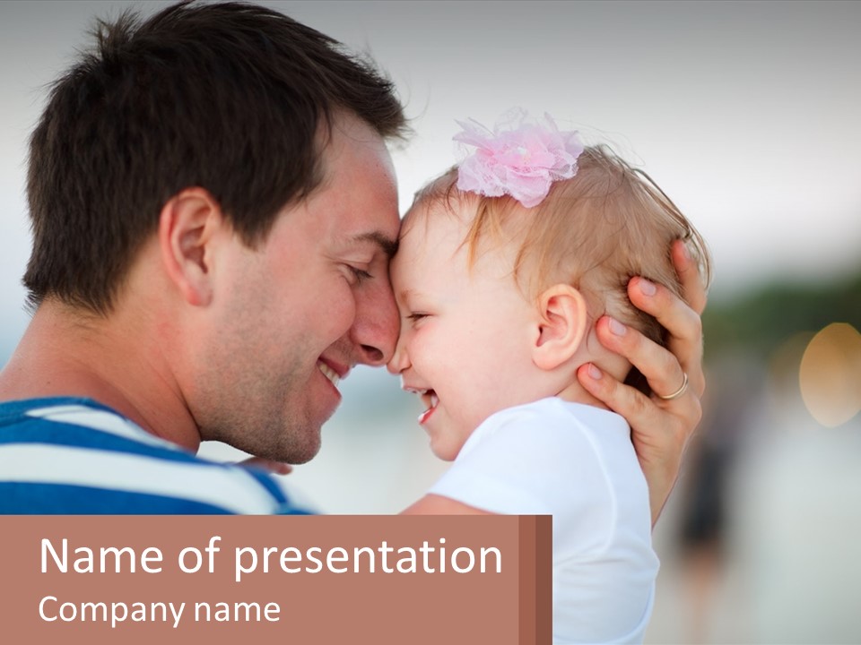 A Man Holding A Baby In His Arms PowerPoint Template