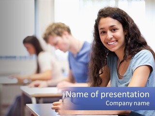 A Woman Sitting At A Desk In A Classroom PowerPoint Template
