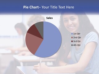 A Woman Sitting At A Desk In A Classroom PowerPoint Template