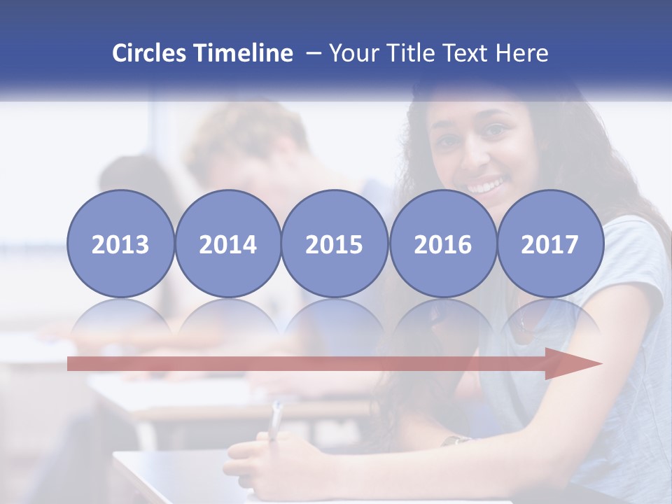 A Woman Sitting At A Desk In A Classroom PowerPoint Template