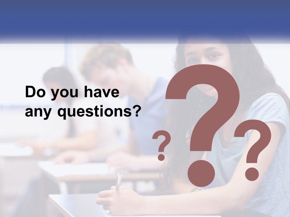 A Woman Sitting At A Desk In A Classroom PowerPoint Template