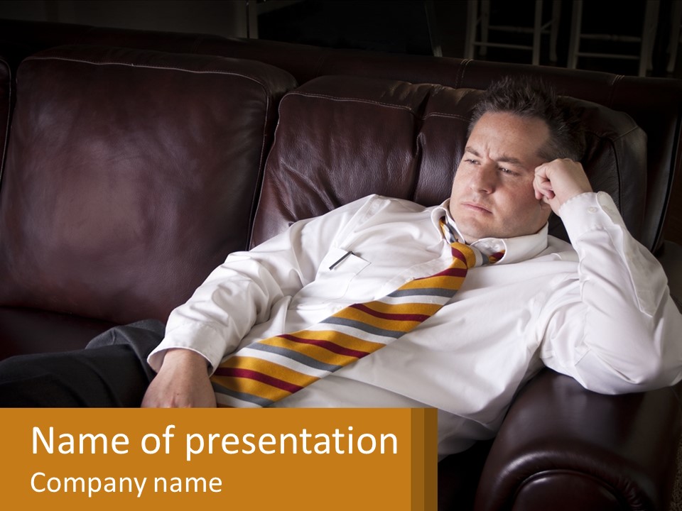 A Man Sitting On A Couch With A Tie On PowerPoint Template