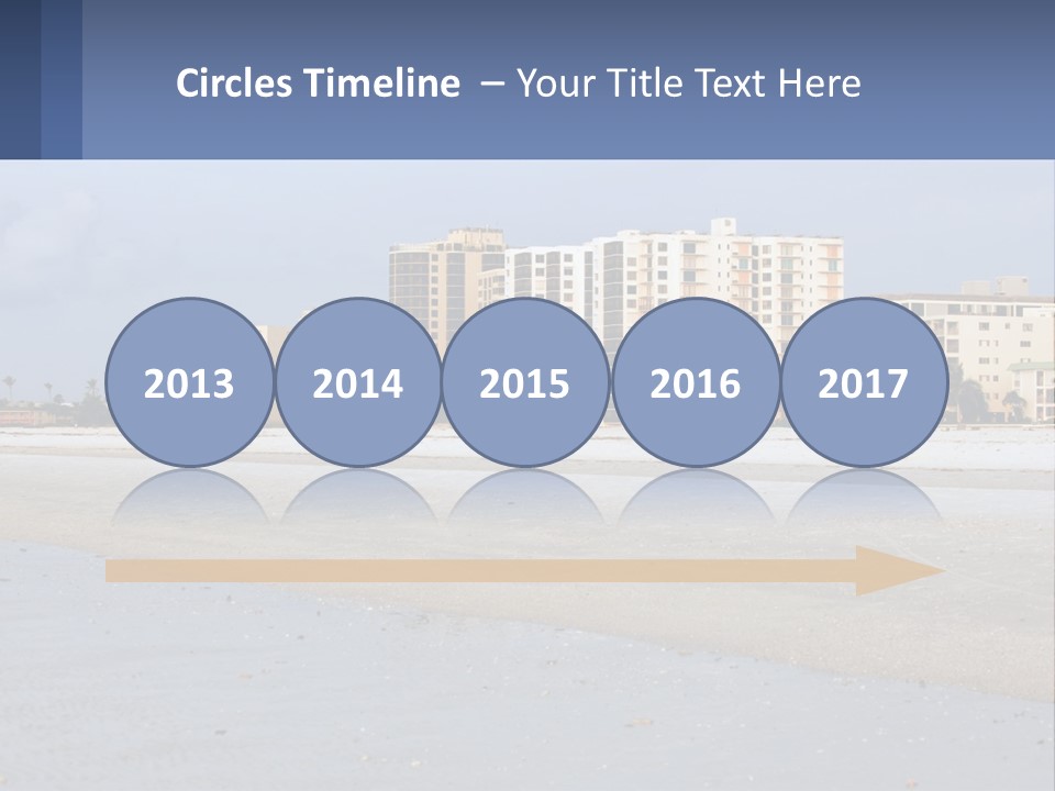 A Sandy Beach With Buildings In The Background PowerPoint Template