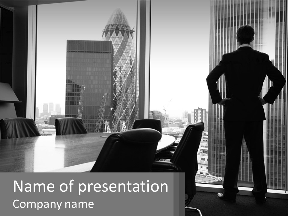 A Man Standing In An Office Looking Out The Window PowerPoint Template