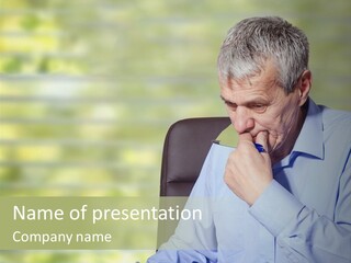A Man Sitting At A Desk With A Pen In His Mouth PowerPoint Template