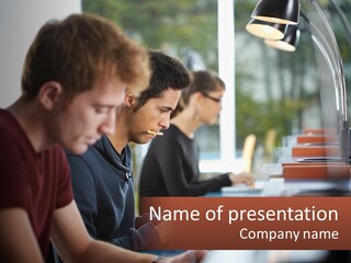 A Group Of Young Men Sitting At A Table Working On Laptops PowerPoint Template