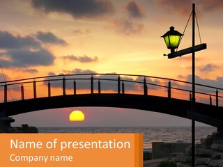 A Bridge Over A Body Of Water At Sunset PowerPoint Template