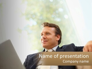 A Man In A Suit Sitting In Front Of A Laptop PowerPoint Template