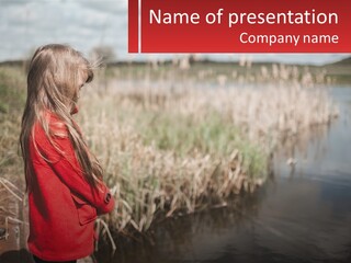 A Little Girl Standing Next To A Body Of Water PowerPoint Template