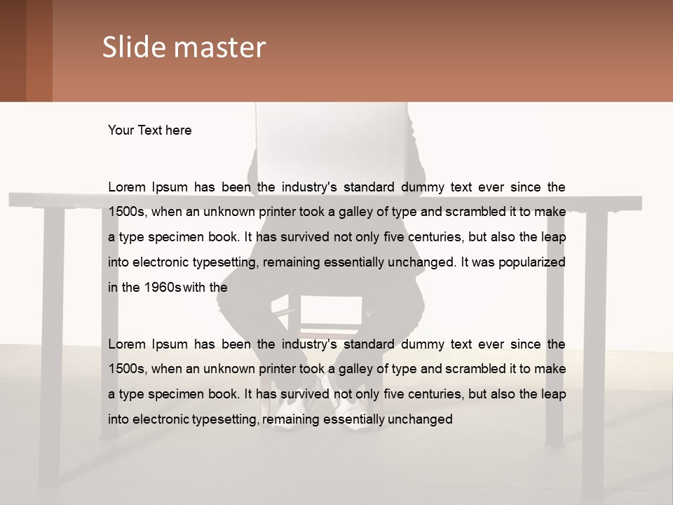 A Man Sitting At A Table Using A Laptop Computer PowerPoint Template