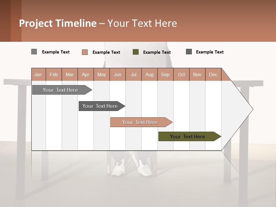 A Man Sitting At A Table Using A Laptop Computer PowerPoint Template