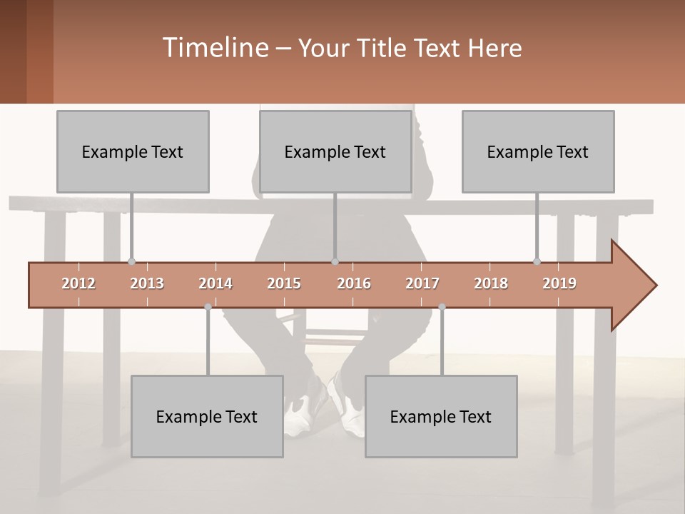 A Man Sitting At A Table Using A Laptop Computer PowerPoint Template