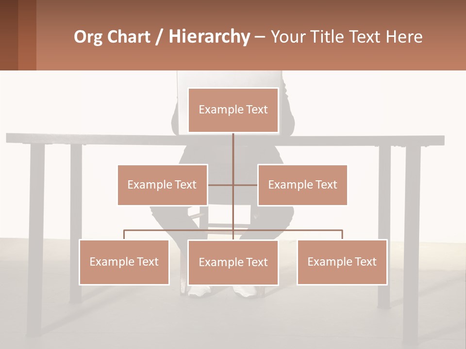 A Man Sitting At A Table Using A Laptop Computer PowerPoint Template