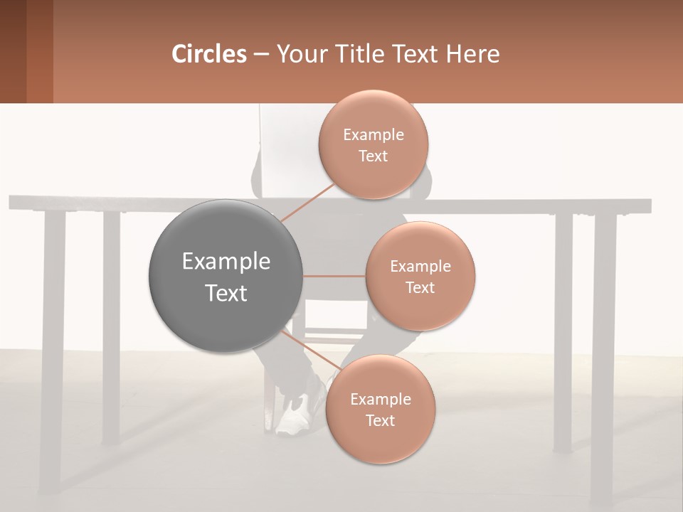 A Man Sitting At A Table Using A Laptop Computer PowerPoint Template