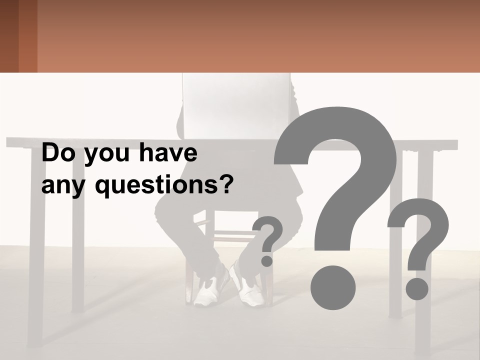 A Man Sitting At A Table Using A Laptop Computer PowerPoint Template