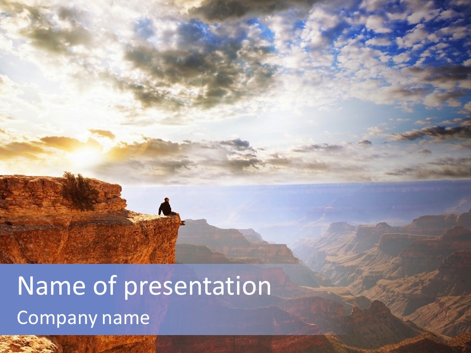 A Person Sitting On Top Of A Cliff Overlooking A Canyon PowerPoint Template