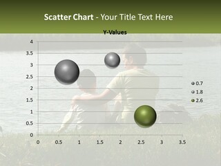 A Man And A Child Sitting On The Grass Near A Body Of Water PowerPoint Template