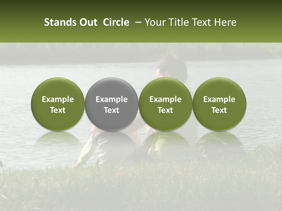 A Man And A Child Sitting On The Grass Near A Body Of Water PowerPoint Template