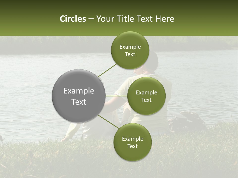 A Man And A Child Sitting On The Grass Near A Body Of Water PowerPoint Template