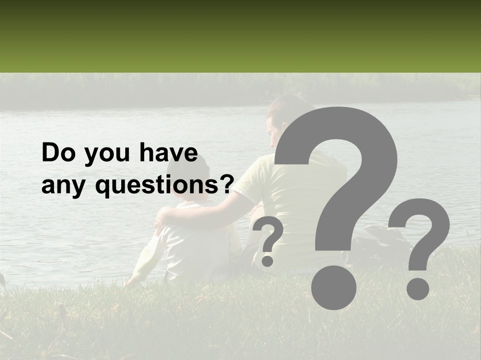 A Man And A Child Sitting On The Grass Near A Body Of Water PowerPoint Template