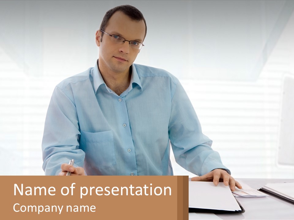 A Man Sitting At A Desk In Front Of A Computer PowerPoint Template