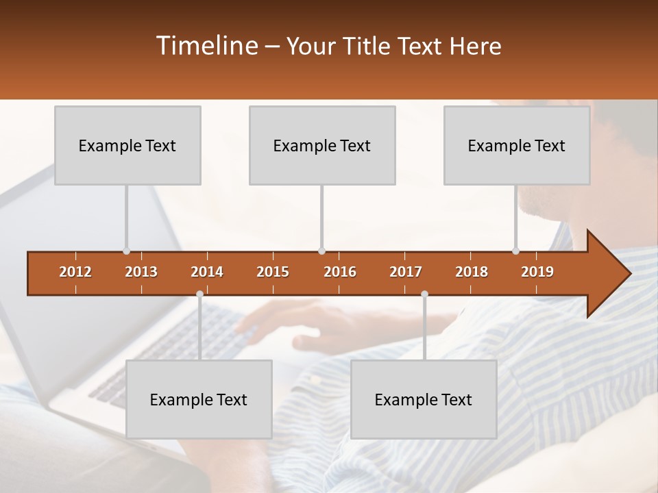A Man Sitting On A Couch Using A Laptop Computer PowerPoint Template