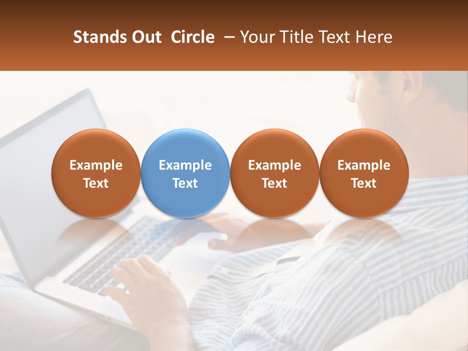 A Man Sitting On A Couch Using A Laptop Computer PowerPoint Template