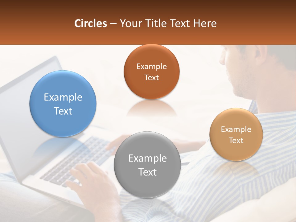 A Man Sitting On A Couch Using A Laptop Computer PowerPoint Template