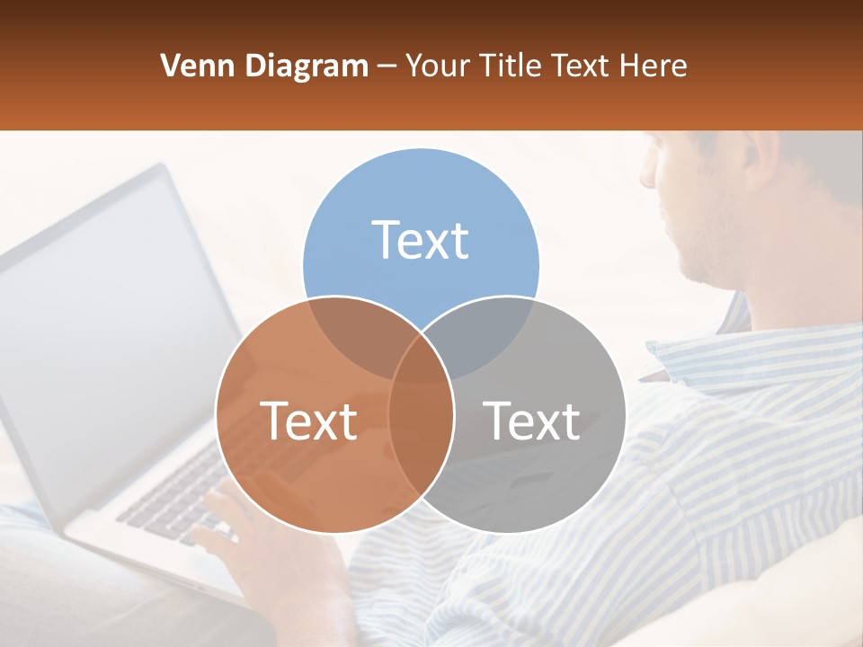 A Man Sitting On A Couch Using A Laptop Computer PowerPoint Template