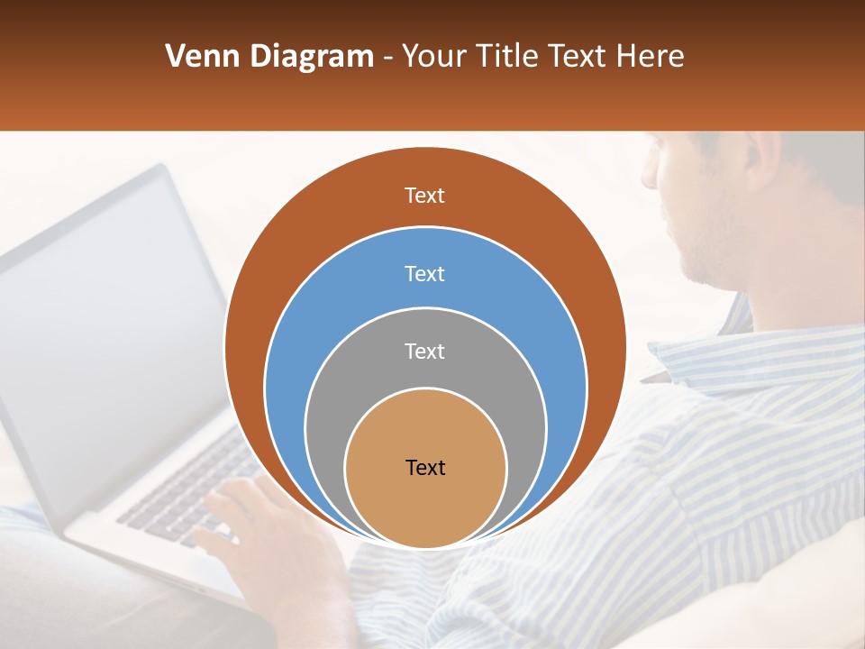 A Man Sitting On A Couch Using A Laptop Computer PowerPoint Template