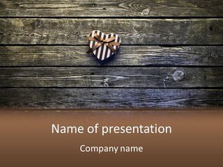 A Present Box On A Wooden Table With A Bow On It PowerPoint Template